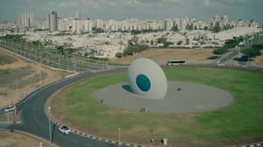 Timelapse video shooting of a roundabout, traffic and city in the background. green square.