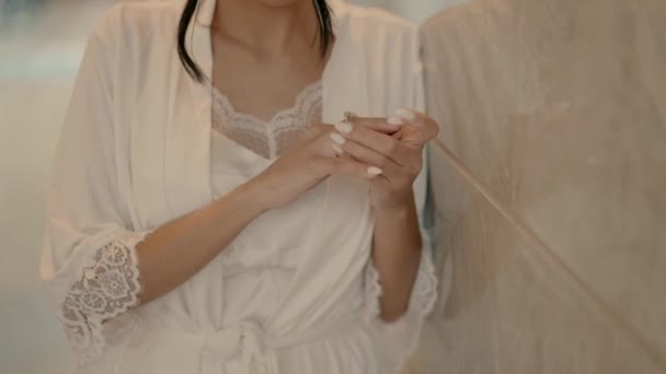 Young Woman White Satin Robe Leans Wall Spins Engagement Ring — Vídeo de stock
