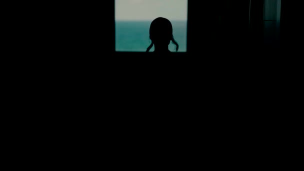 暗闇の中で窓の外を歩いている若い女性のシルエット 結婚式の日のウィンドウによって花嫁のスローモーションビデオ — ストック動画