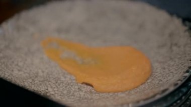 A waiter puts mashed potatoes and beef on a gray plate on the black table in a restaurant.