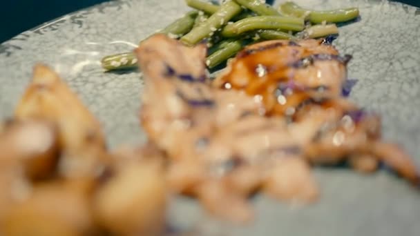 灰色のプレートとチキンステーキのクローズアップビデオ 豆とジャガイモはそれに揚げられています — ストック動画