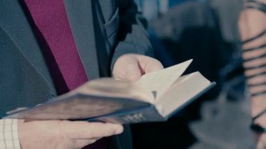 An elderly Jewish man prays standing with a Bible. close up