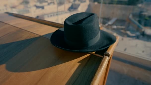 Ein Schwarzer Orthodoxer Hut Liegt Morgens Auf Dem Holztisch Auf — Stockvideo