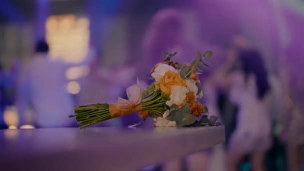 一束黄色和白色的花躺在吧台上 在后台跳舞 婚礼庆典期间 酒吧里的新娘花束 慢动作视频 — 图库视频影像