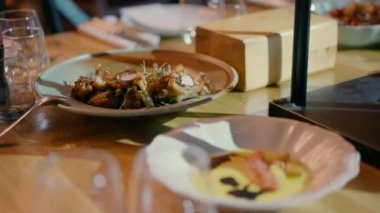 Beyaz tabaklar ve gözlüklerle güzel bir yemek masası. Etkinlik salonunda masada yemek olan bir tabak..