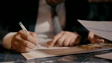 Elinde kalem olan takım elbiseli bir adam bir belge imzalamaya hazır. Ofis işi