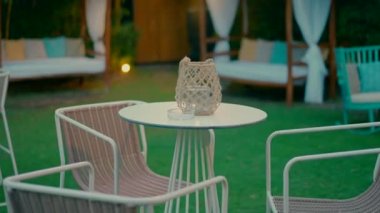Yuvarlak bir masa ve güzel bahçede üç sandalye. Yüksek kaliteli FullHD görüntüler