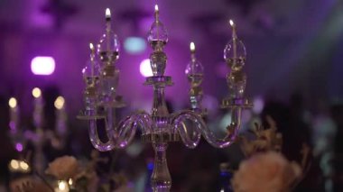 Koyu ziyafet salonunda parıldayan zarif yağ mumlarını kapatın. Sıcak mum ışığında romantik bir ortam, düğün, resepsiyonlar, kutlamalar, lüks yemekler ve şenlikli etkinlikler için mükemmel..