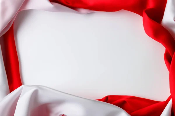 kırmızı ve beyaz çift renkli kumaş desenli beyaz arkaplan, dalgalı dekoratif kurdele, mesaj veya metin için merkezde boşluk, kavramsal duvar kağıdı