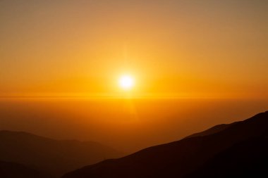 Dağın üzerinden gün doğuyor.