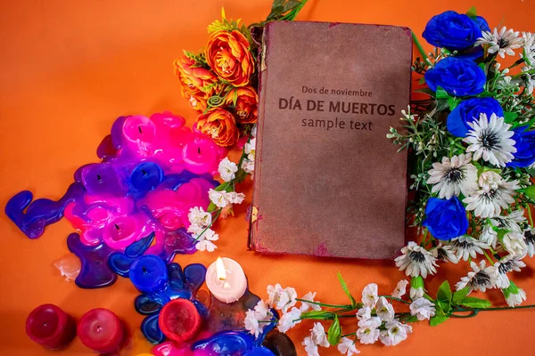 Renkli çiçekler ve ahşap bir masanın üzerinde eski bir kitap. Cadılar Bayramı konsepti