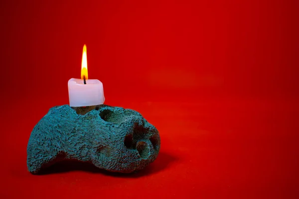 stock image a red burning candle on a blue background