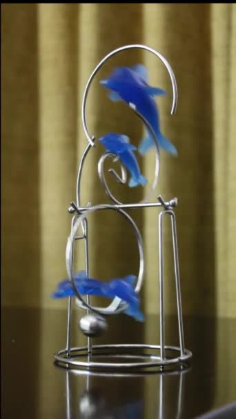 青いイルカの形をした振り子がテーブルの上で — ストック動画