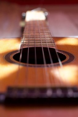 Bulanık arkaplanı olan akustik gitarın dikey yakın çekimi