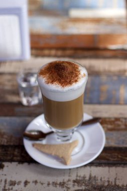 Restoran masasındaki cam bardakta kapuçino.