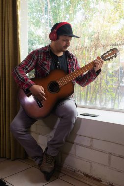 Gitar çalan kulaklıklı adam.