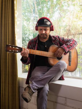 Evde gitar çalan adam.