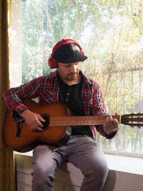 Gitar çalan kulaklıklı adam.