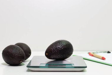 Ölçek, ağırlık kontrolü ve gıda güvenliği kavramında bir avokado