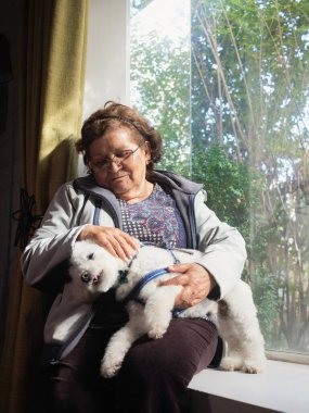 Latin yaşlı kadın köpeğiyle dinleniyor.