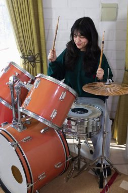 Latin kadın evde davul çalıyor.