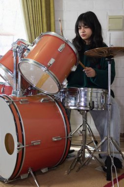 Kadın davulcu evde çalıyor