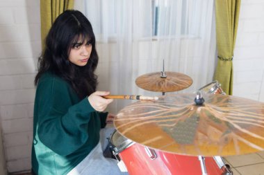 Kadın akustik davul eğitimi alıyor.