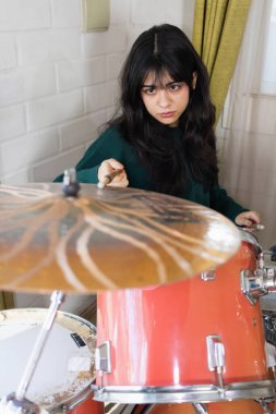 Kadın akustik davul eğitimi alıyor.