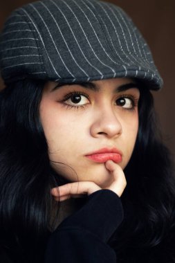 Gazeteci şapkası takan genç bir kızın portresi.