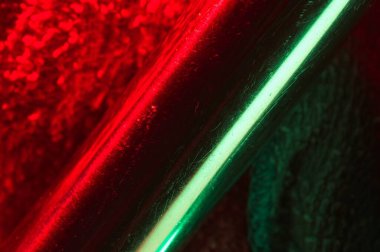 Metalik saptaki kırmızı ve yeşil yansımaların soyut arkaplanı
