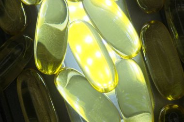 Parlak bir ışıkta soyut E vitamini kapsülleri