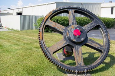 Large Gear Wheel on display outside a factory clipart