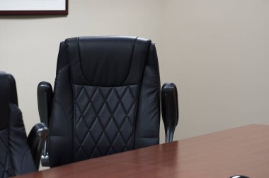 Black leather office chair at a conference table clipart