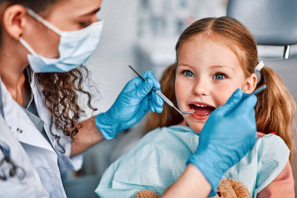 At the doctor's appointment. Portrait of a child being examined by a dentist.