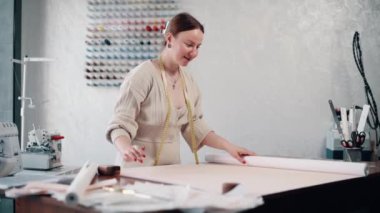 Moda tasarımcısı atölyede desenler çizer.