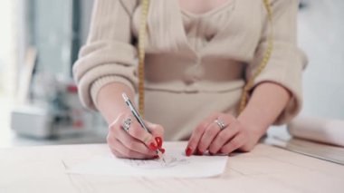 Kadın moda tasarımcısı atölyede eskizler çiziyor..