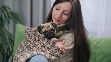 Metresinin elinde sevimli bir köpek yavrusu. Genç bir kadın köpeğini kollarında tutuyor..