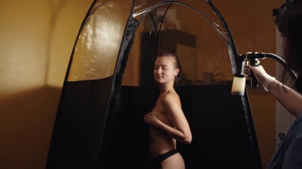Cosmetologist Using Airbrush Spray Tan Apply Young Woman Body Beauty — Αρχείο Βίντεο