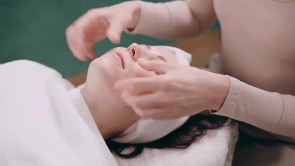 Vackerskan Masserar Ansiktet Ung Kvinna Ligger Rygg Och Får Ansiktslyftning — Stockvideo