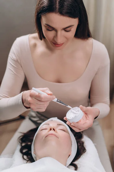 Cosmetólogo Aplica Una Máscara Hidratante Cara Los Clientes Con Cepillo — Foto de Stock