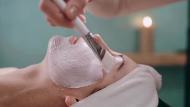 Die Kosmetikerin Trägt Mit Einem Pinsel Eine Feuchtigkeitsspendende Maske Auf — Stockvideo