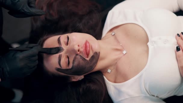 Cosmetólogo Aplicando Máscara Negra Cara Mujer Bonita Mujer Spa Con — Vídeo de stock