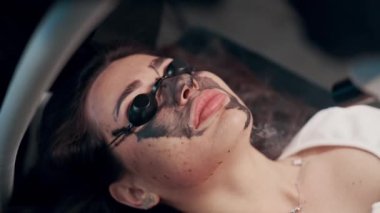 Spa salonunda lazer karbon soyma ile yüz temizleme prosedürü. Üst görünümü kapat.