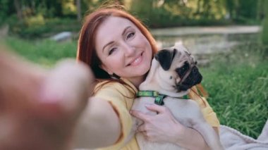 Mutlu kadın köpeğiyle selfie çekiyor. Bir kadın kollarında bir köpek taşıyor. Komik köpek kameraya bakıyor. POV.