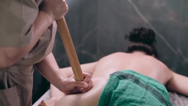 Ung Kvinna Med Bambu Pinnar Massage För Ben Och Skinka — Stockvideo