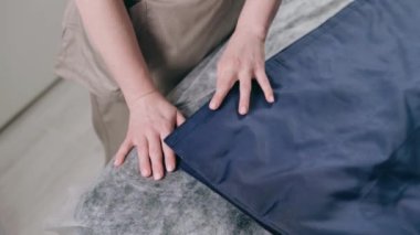 Bambu çubuklarıyla masaj. Profesyonel bir masaj terapisti salonda masaj için ısıtılmış bambu çubukları alır. Üst görünümü kapat.