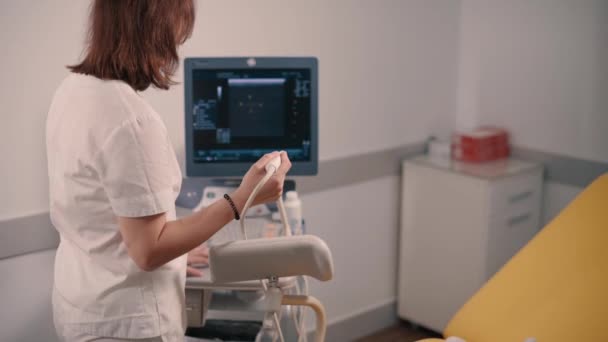 Ung Kvinnlig Läkare Justerar Ultraljudsmaskin Kliniken — Stockvideo