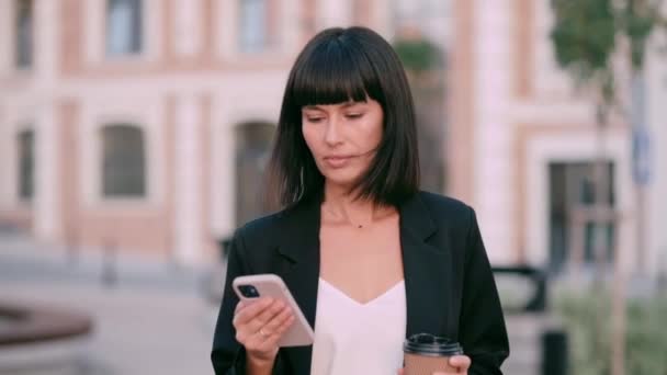 Mulher Negócios Usando Smartphone Uma Jovem Caminha Pela Cidade Com — Vídeo de Stock