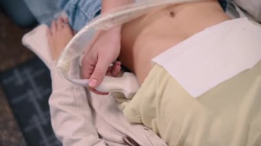 Bir doktor klinikteki genç bir kadının böbreklerinin ultrason taramasını yapar.. 