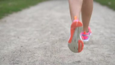 Bir yaz günü yolda koşan bir kadın koşucunun bacakları, yakın çekim, yavaş çekim